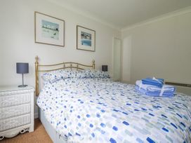 A bedroom with a bed and nightstand at Acorns, Falmouth