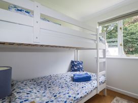 A bedroom with a bunk bed and a window at Acorns in Falmouth