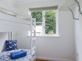 A bedroom with a bunk bed and a window at Acorns in Falmouth