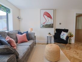 A living room with a flamingo painting and a sofa at 1 Mill Green Court, Lyme Regis