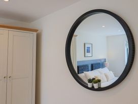 A bedroom with a mirror and wardrobe at 1 Mill Green Court in Lyme Regis