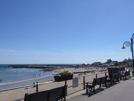 A beach view with benches and people at 1 Mill Green Court Lyme Regis
