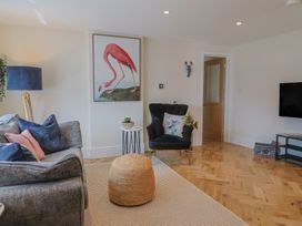 A living room with a sofa, chair, and TV at 1 Mill Green Court in Lyme Regis
