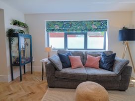 A living room with a sofa and display cabinet at 1 Mill Green Court in Lyme Regis
