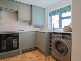 A kitchen with oven, sink, and washing machine at 1 Mill Green Court, Lyme Regis