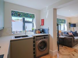 A kitchen with a washing machine and window at 1 Mill Green Court in Lyme Regis