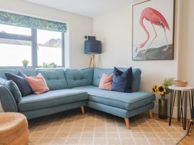 A living room with a blue sofa and wall art at 1 Mill Green Court in Lyme Regis