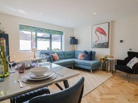 A living room with a sofa and dining table at 1 Mill Green Court in Lyme Regis