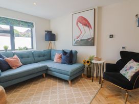 A living room with a blue sofa and a black armchair at 1 Mill Green Court in Lyme Regis