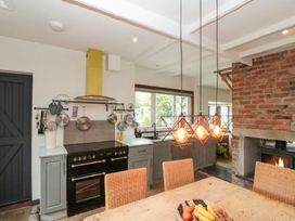 A kitchen with an oven, stove, and dining table at Sea Haven Hunmanby Gap near Primrose Valley