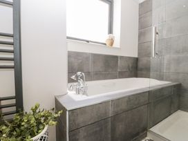 A bathroom with a bathtub and shower at Sea Haven Hunmanby Gap near Primrose Valley