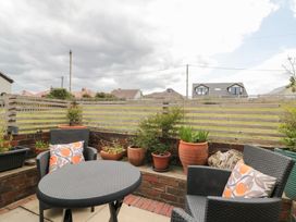 An outdoor seating area with a table and plant pots at Sea Haven in Hunmanby Gap near Primrose Valley