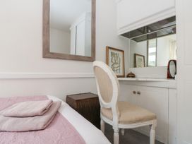 A bedroom with a bed, chair, and mirror at Sea Haven near Primrose Valley
