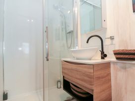 A bathroom with a shower and sink at Sea Haven Hunmanby Gap near Primrose Valley
