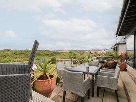 An outdoor seating area with a table and chairs at Sea Haven near Hunmanby Gap