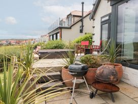 An outdoor area with grills and a hot tub at Sea Haven in Hunmanby Gap near Primrose Valley