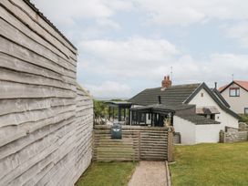 An outdoor view of a house with a pathway and fence at Sea Haven in Hunmanby Gap near Primrose Valley