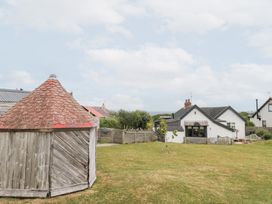 A garden with a wooden structure and house at Sea Haven in Hunmanby Gap near Primrose Valley