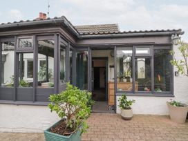 A conservatory with multiple plants and a doorway at Sea Haven Hunmanby Gap near Primrose Valley