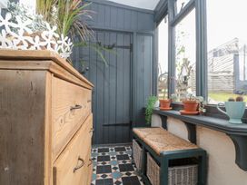A hallway with a wooden chest of drawers and potted plants at Sea Haven, Hunmanby Gap near Primrose Valley