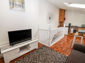 A living room with a tv and kitchen in Bobby's Whitby