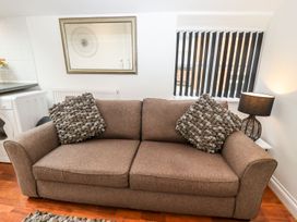 A living room with a brown sofa and a mirror at Bobby's in Whitby