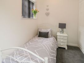 A bedroom with a single bed, nightstand, and lamp at Ted's Place in Whitby