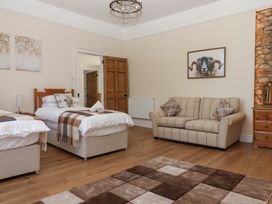 A bedroom with two beds and a sofa at Littleham Court Manor near Bideford