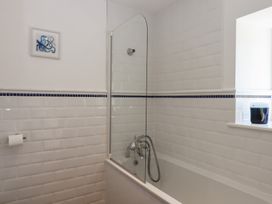 A bathroom with a bathtub and shower screen at Littleham Court Manor in Littleham near Bideford