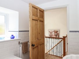A bathroom with a wooden door and window at Littleham Court Manor in Littleham near Bideford
