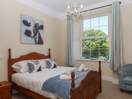 A bedroom with a bed and a painting at Littleham Court Manor in Littleham near Bideford