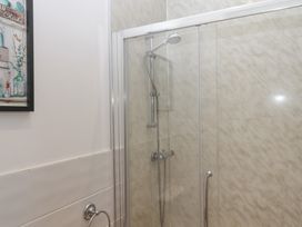 A shower with glass door and wall art in a bathroom at Littleham Court Manor Littleham near Bideford