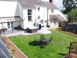 A garden with a hot tub and seating area at Littleham Court Manor Littleham near Bideford