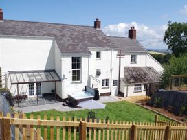An outdoor view of a house with a hot tub and garden at Littleham Court Manor in Littleham near Bideford