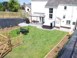 A garden with grass, a table and chairs and a parasol at Littleham Court Manor in Littleham near Bideford