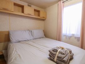 A bedroom with a bed and shelves at the Caravan in Northampton