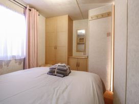 A bedroom with a bed and wardrobe at Caravan Northampton