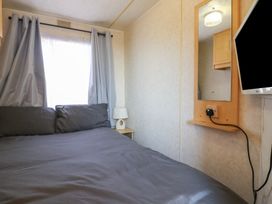 A bedroom with a bed and a TV at Caravan in Northampton