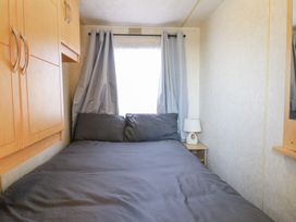 A bedroom with a bed and bedside table at Caravan in Northampton