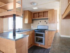 A kitchen with an oven and sink at Caravan in Northampton