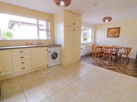 A kitchen with a dining area and a washing machine at Ard Na Mara