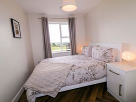 A bedroom with a bed and a bedside table at Ard Na Mara