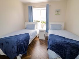 A bedroom with two single beds and a window at Ard Na Mara