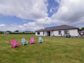 A house with chairs and a lawn at Ard Na Mara 