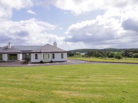 A house with a lawn and trees at Ard Na Mara