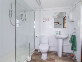 A bathroom with a shower, toilet, and sink at Shepherd's Hut Market Weighton
