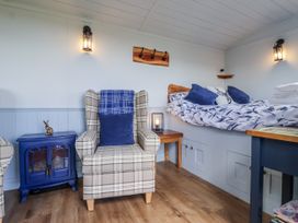 A bedroom with armchair and bed at Wolds Hoot in Market Weighton
