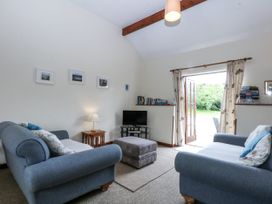 A living room with sofas and a television at Florence Cottage in Holyhead