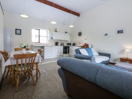 A living room with a dining area and kitchen appliances at Florence Cottage in Holyhead