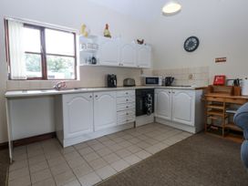 A kitchen with cabinets, sink, and appliances at Florence Cottage in Holyhead